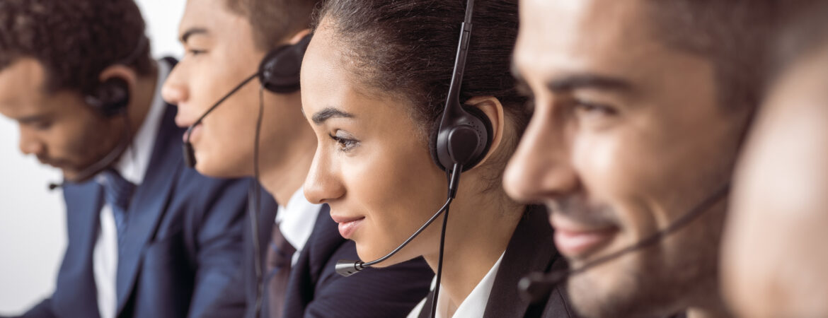 Close-up view of call center operators in headsets working together